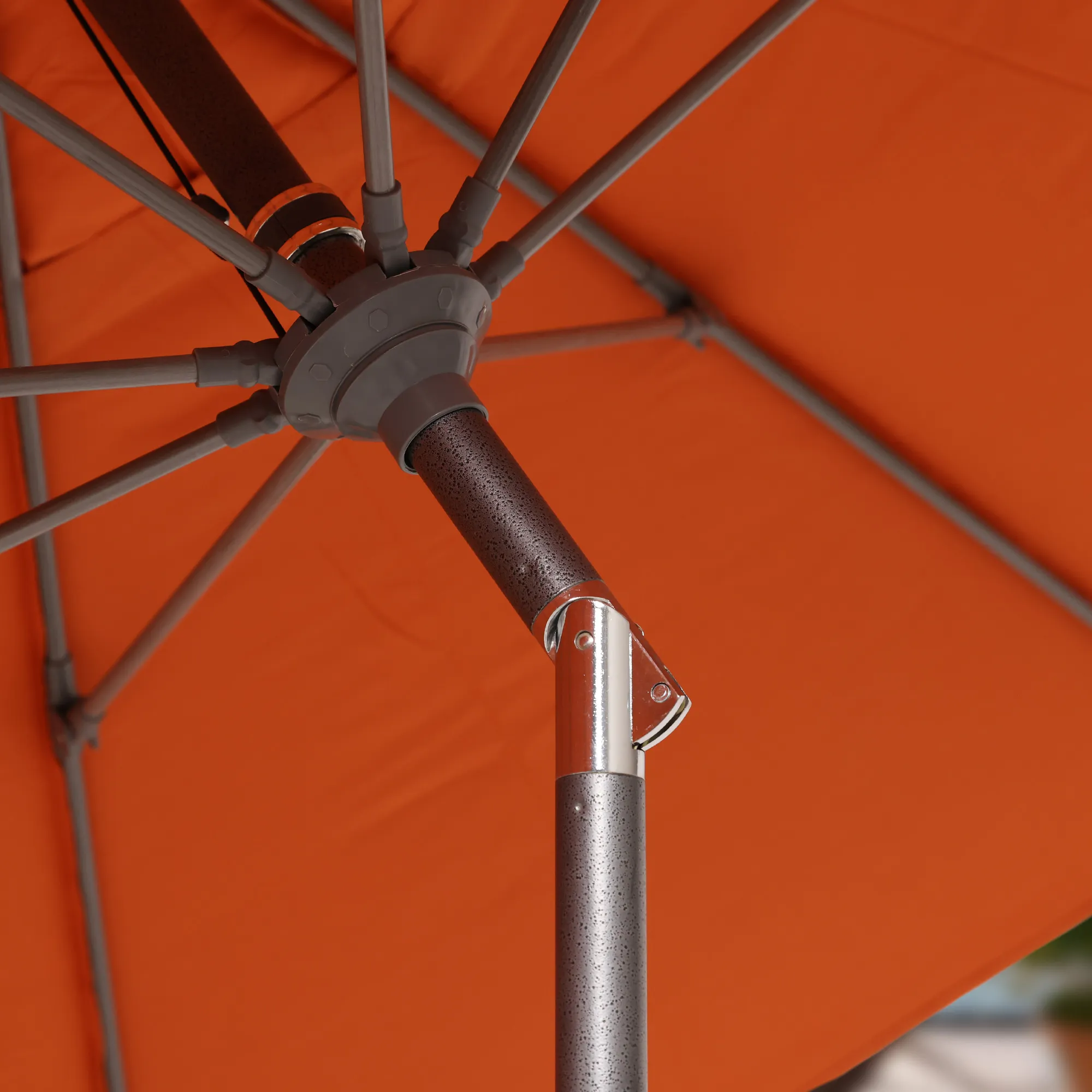 Close-up image of the revolutionary collar tilt mechanism on the Sun Master Series Patio Umbrella by California Umbrella. This feature allows for easy angle adjustments, enabling users to optimize shade coverage as the sun moves. The mechanism is highlighted against the durable aluminum pole of the umbrella, demonstrating its seamless integration and ease of use. Perfect for enhancing outdoor comfort, this collar tilt mechanism represents a blend of innovation and practicality in umbrella design.